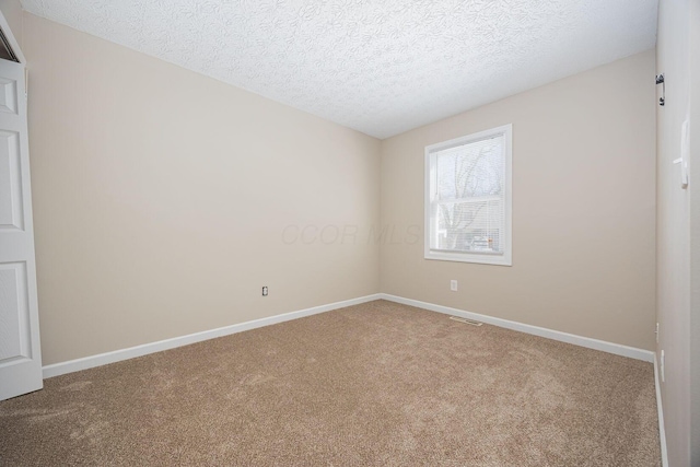 carpeted spare room with a textured ceiling