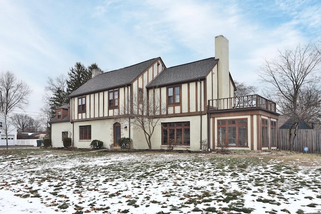 snow covered house with a balcony and a sunroom