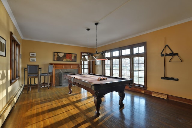 rec room featuring a baseboard heating unit, dark wood-type flooring, a fireplace, and ornamental molding