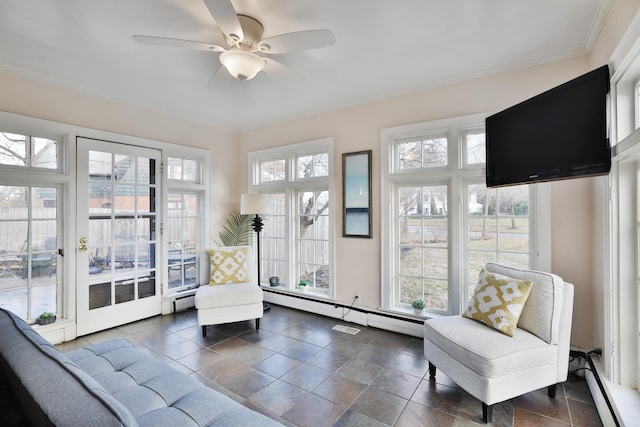 sunroom featuring a baseboard radiator and ceiling fan