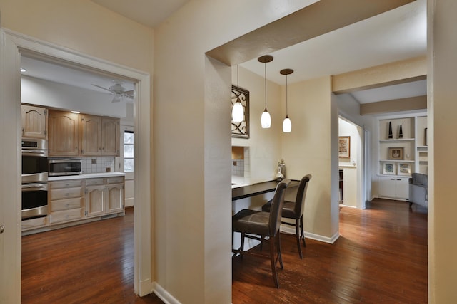 kitchen with pendant lighting, appliances with stainless steel finishes, dark hardwood / wood-style flooring, and light brown cabinetry