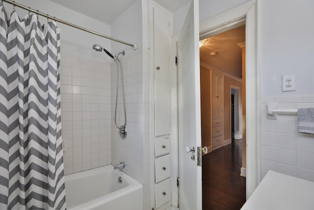 bathroom with shower / bathtub combination with curtain, wood-type flooring, and tile walls