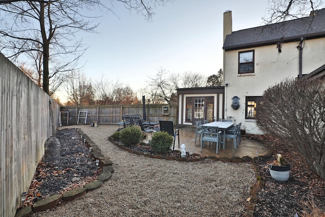 yard at dusk featuring a patio