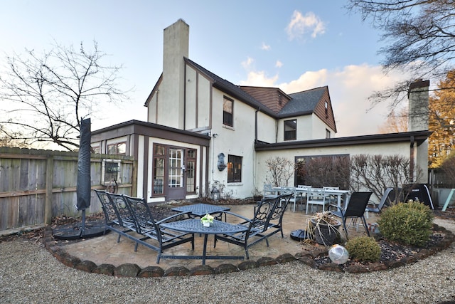 back house at dusk with a patio area