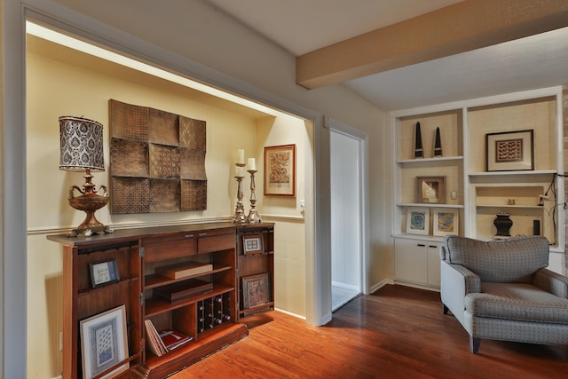 living area featuring dark wood-type flooring, built in features, and beamed ceiling