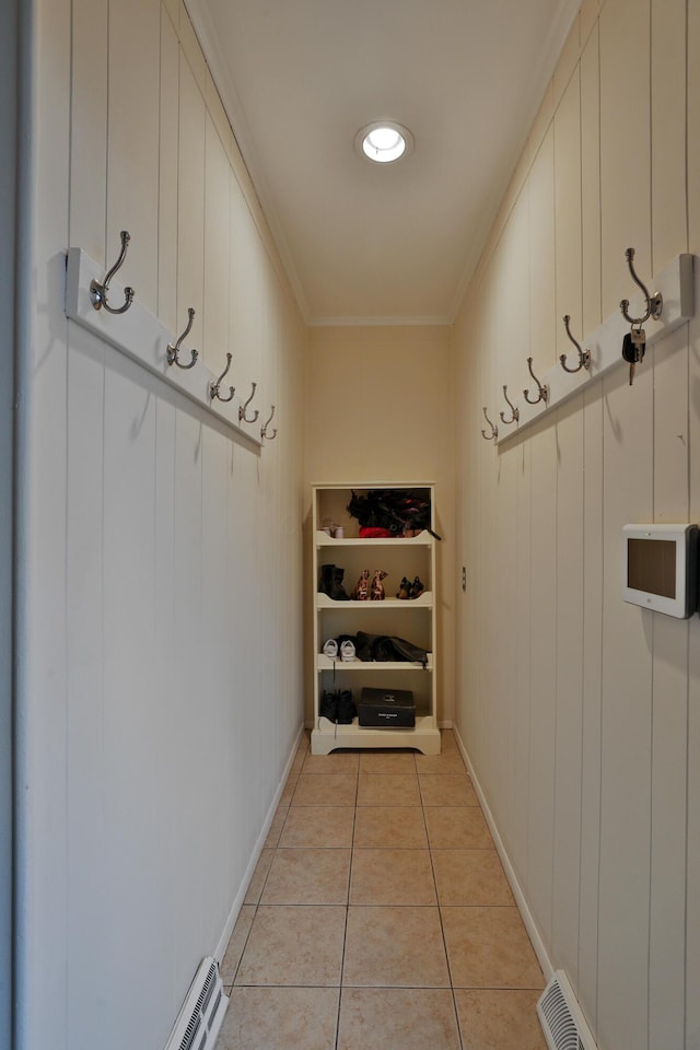 mudroom featuring ornamental molding and light tile patterned flooring