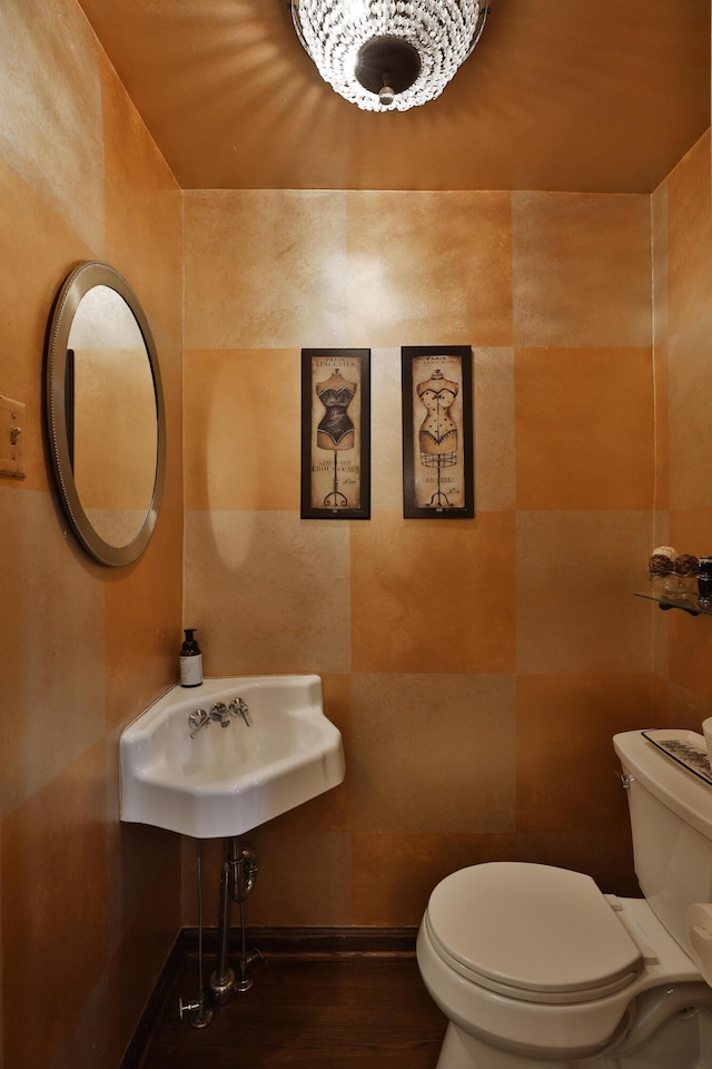 bathroom featuring sink, tile walls, and toilet