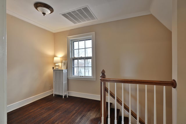 staircase featuring hardwood / wood-style flooring and radiator heating unit