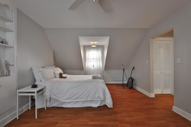 bedroom featuring baseboard heating, ceiling fan, lofted ceiling, and hardwood / wood-style floors