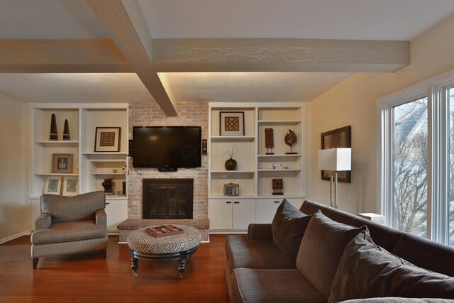 living room with a fireplace, beam ceiling, wood-type flooring, and built in shelves