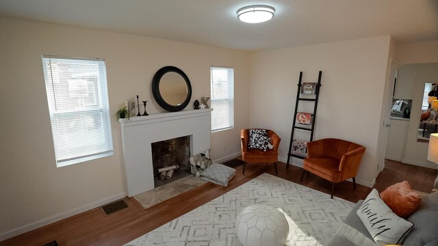 1807 Weiler Ave, Columbus, OH 43207 - sitting room featuring wood finished floors, a brick fireplace, and baseboards