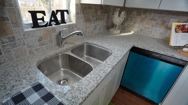 1807 Weiler Ave, Columbus, OH 43207 - kitchen view of dishwashing machine, a sink, white cabinetry, decorative backsplash, and light stone countertops