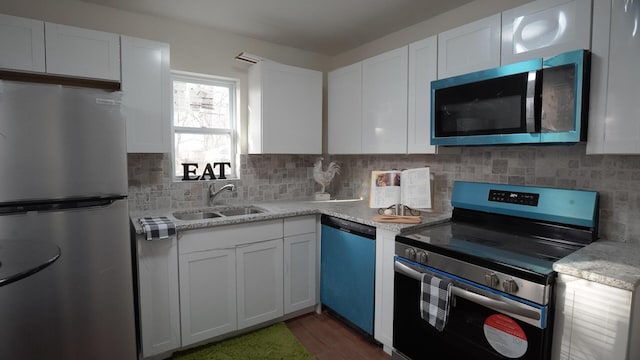 1807 Weiler Ave, Columbus, OH 43207 - kitchen with stainless steel appliances, a sink, white cabinetry, and backsplash