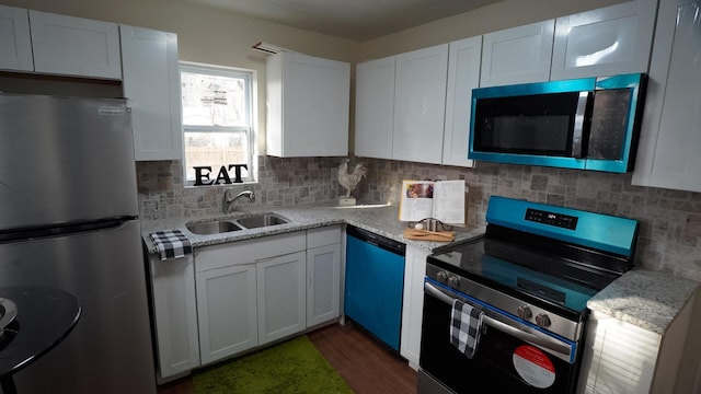 1807 Weiler Ave, Columbus, OH 43207 - kitchen with appliances with stainless steel finishes, a sink, dark wood-style floors, tasteful backsplash, and white cabinetry