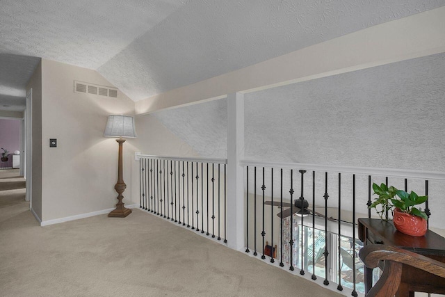 hallway with carpet flooring and vaulted ceiling