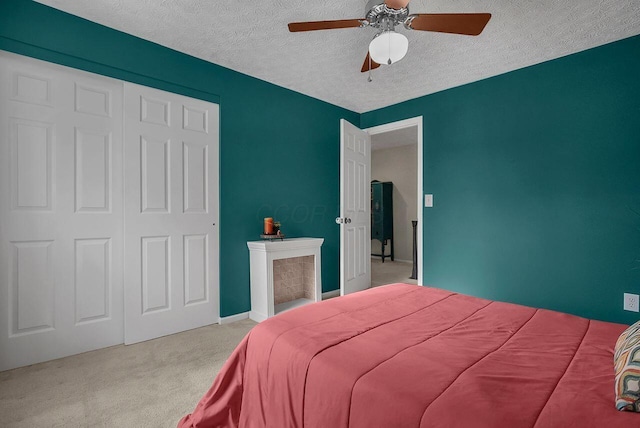 carpeted bedroom featuring a textured ceiling, a closet, and ceiling fan