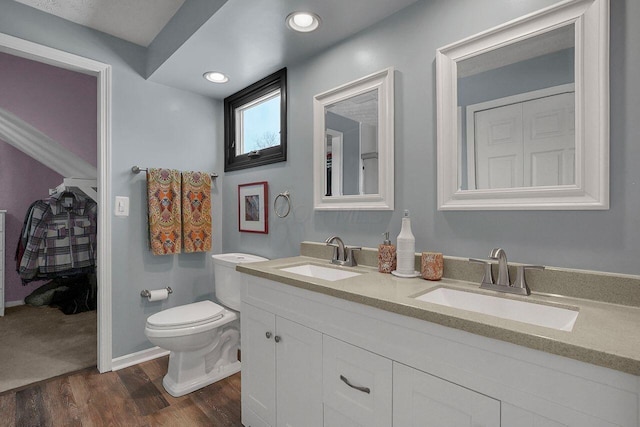 bathroom with hardwood / wood-style flooring, toilet, and vanity