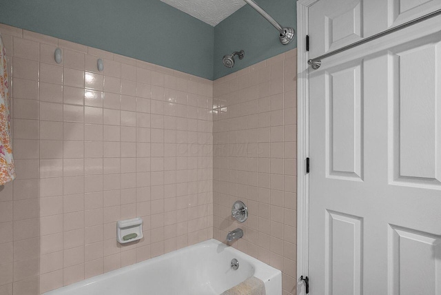 bathroom with tiled shower / bath combo and a textured ceiling