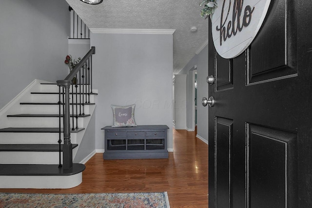 entryway featuring a textured ceiling, dark hardwood / wood-style floors, and crown molding