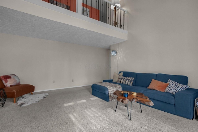 living room with a towering ceiling and carpet flooring