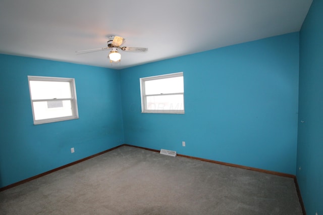 carpeted spare room featuring ceiling fan