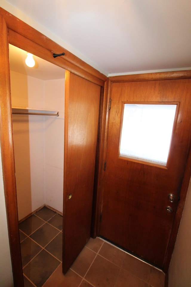 doorway with dark tile patterned floors