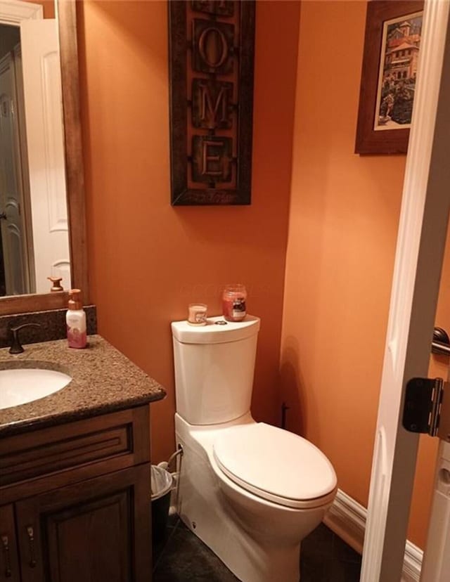 bathroom featuring vanity, tile patterned floors, toilet, and baseboards