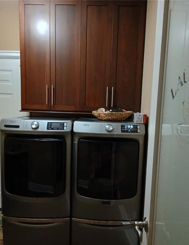 washroom with washer and dryer and cabinet space