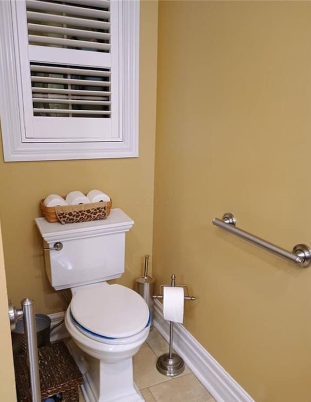 bathroom with tile patterned floors, baseboards, and toilet