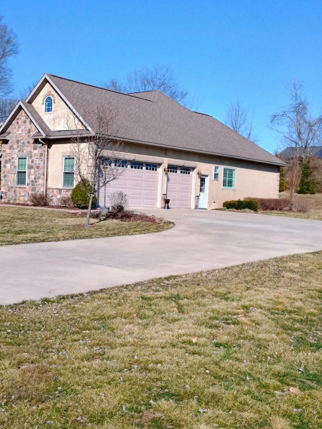 view of front of home featuring a front yard, an attached garage, driveway, and stucco siding