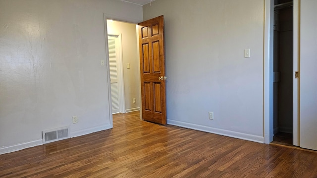 unfurnished bedroom featuring dark hardwood / wood-style flooring, a closet, and a spacious closet