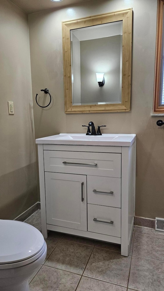 bathroom with toilet, tile patterned flooring, and vanity