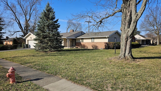 single story home featuring brick siding, a front yard, a chimney, a garage, and driveway