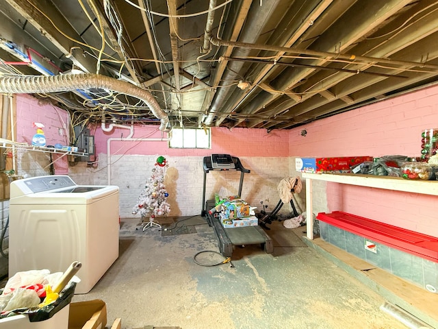 basement featuring brick wall and washer / clothes dryer