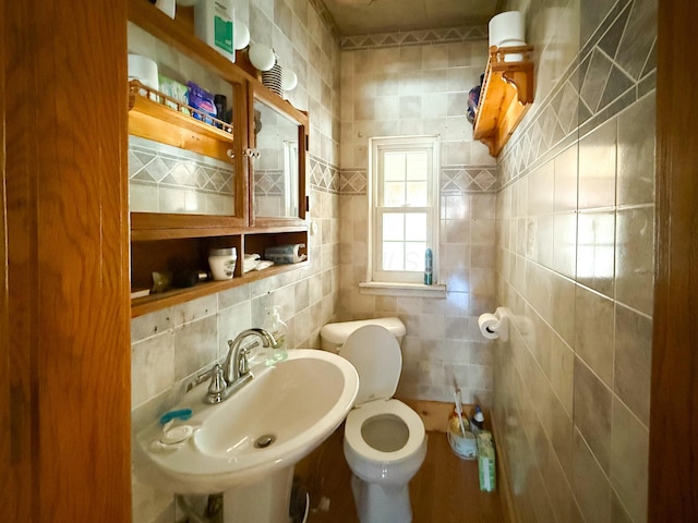 bathroom featuring backsplash, tile walls, toilet, and sink