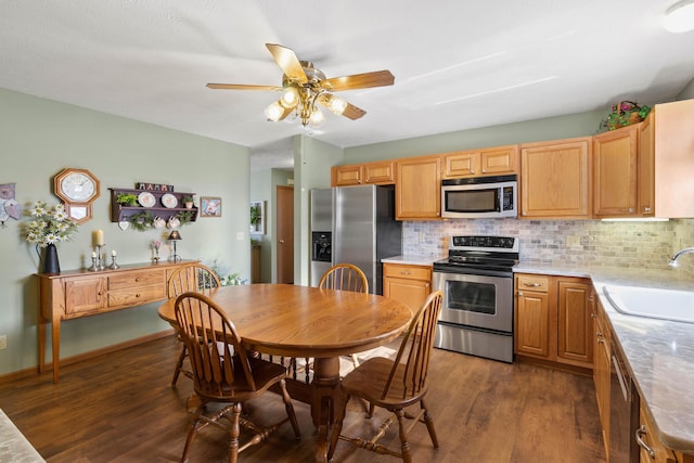 kitchen featuring dark hardwood / wood-style flooring, stainless steel appliances, decorative backsplash, sink, and ceiling fan