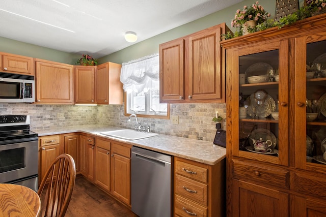 kitchen with dark wood-type flooring, sink, appliances with stainless steel finishes, and tasteful backsplash