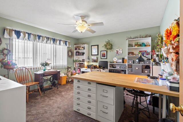 office featuring ceiling fan, a textured ceiling, and dark colored carpet