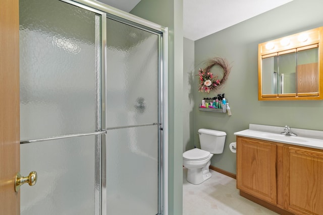 bathroom featuring toilet, a shower with door, and vanity