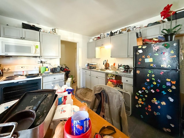 kitchen featuring sink, white appliances, and light stone countertops