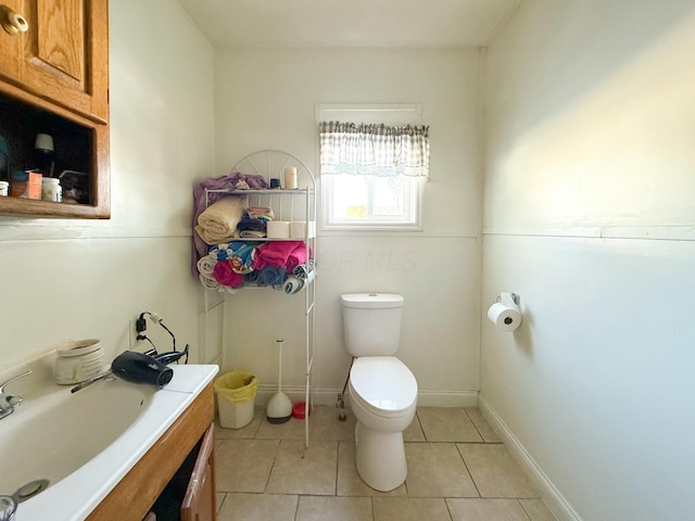 bathroom with toilet, tile patterned flooring, and vanity