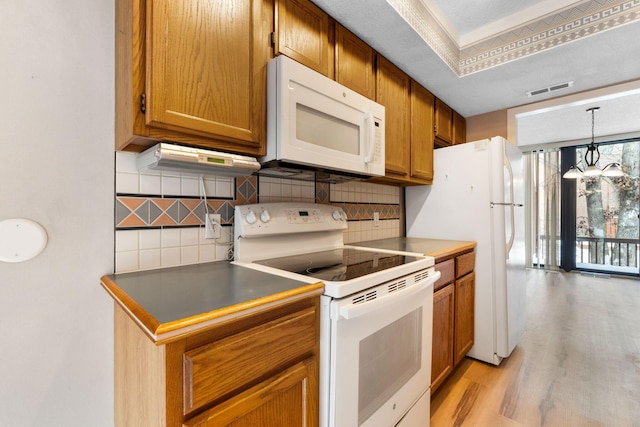 kitchen featuring light hardwood / wood-style floors, backsplash, white appliances, a chandelier, and pendant lighting