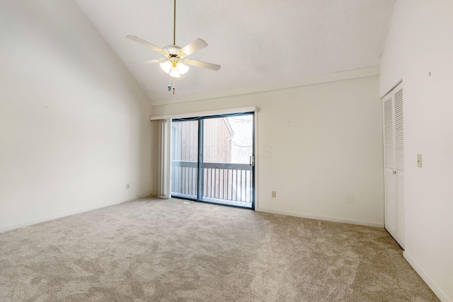 empty room featuring ceiling fan, light colored carpet, and high vaulted ceiling