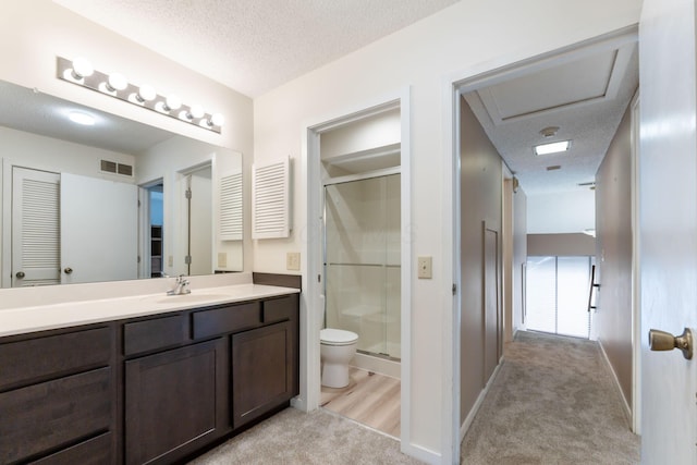 bathroom with walk in shower, vanity, toilet, and a textured ceiling