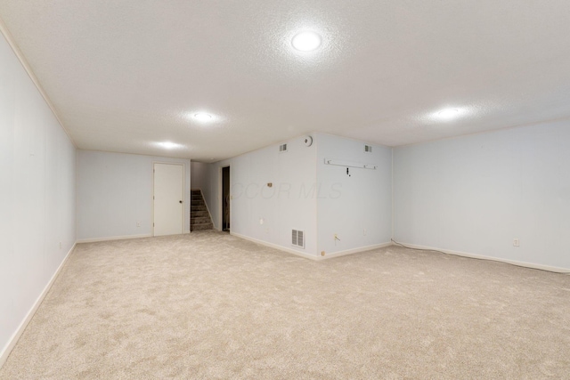 basement with light colored carpet and a textured ceiling