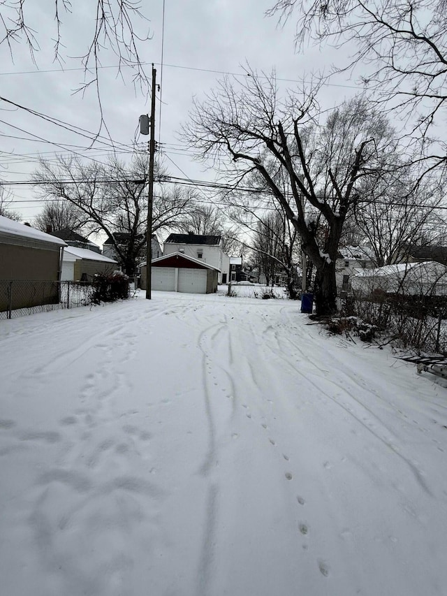 yard covered in snow featuring a garage