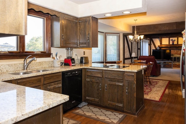 kitchen with a chandelier, black appliances, hanging light fixtures, kitchen peninsula, and dark hardwood / wood-style floors