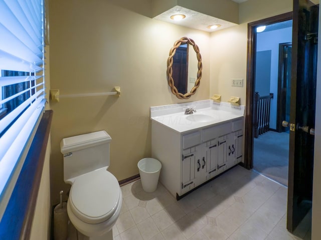 bathroom featuring tile patterned flooring, vanity, and toilet