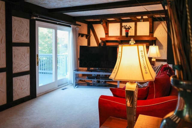 carpeted living room featuring beamed ceiling