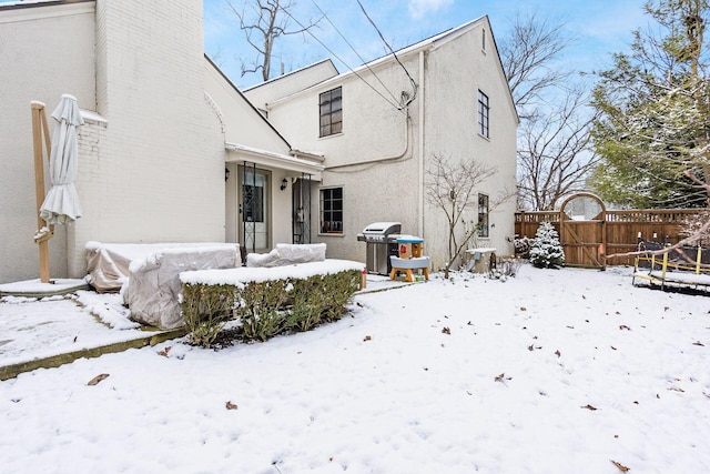 view of snow covered back of property